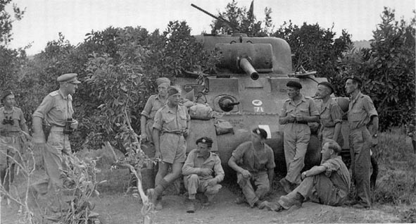 4th Armoured Brigade HQ with Brigadier Curry (Binoculars). Note Black Rat TAC sign and 71 which denote the unit is independent armoured brigade HQ. Also note RAC Red, White, Red bars on front of Sherman hull used for recognition purposes.