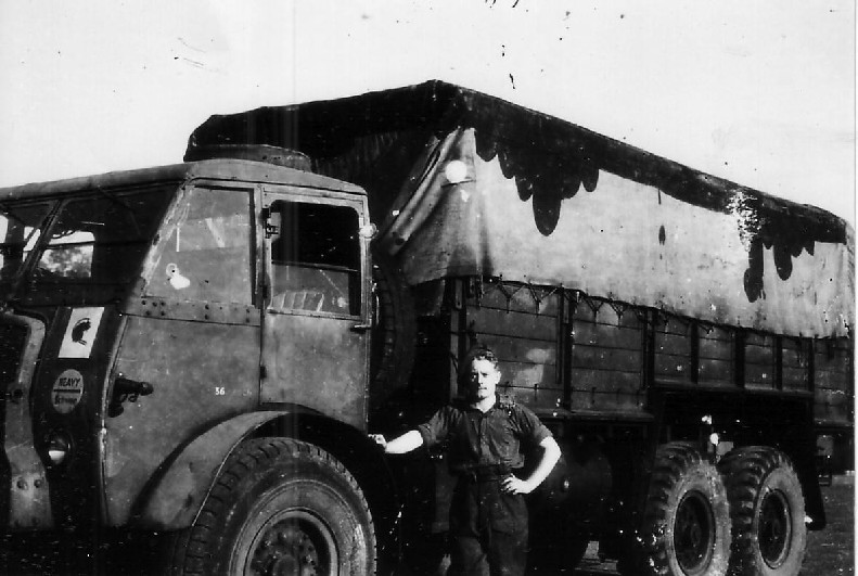 A lorry from No 5 Company, RASC, with its Driver. Note the 'Micky Mouse' Camouflage and the clear Brigade badge of the front nearside.