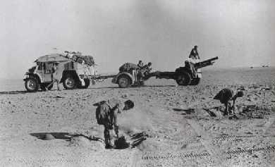 Men from 4th RHA digging a gun pit, while the 25pdr Gun, Limber and Quad Tractor wait in the background.